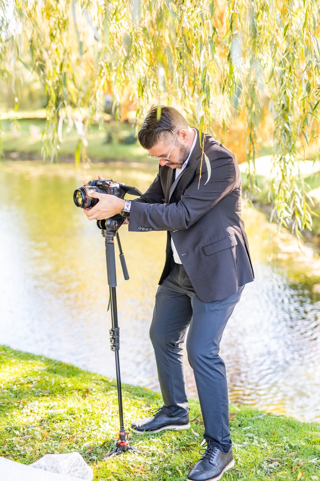 John filming beneath a willow tree by the water.